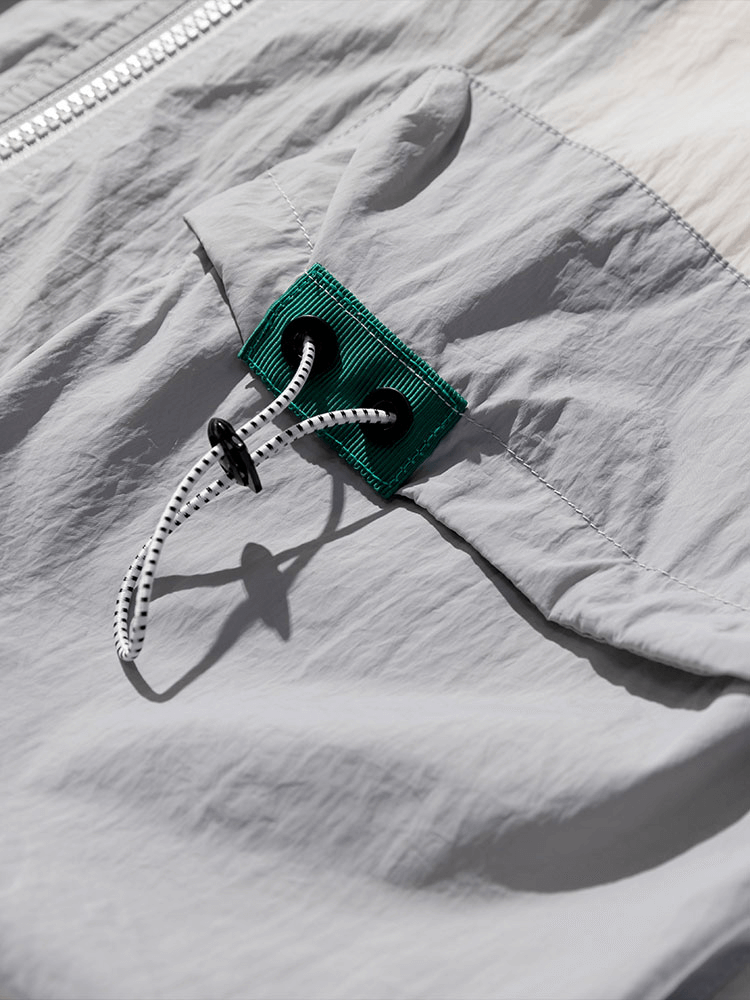 Close-up of ultra-light windbreaker showing drawstring feature, highlighting waterproof material and stylish design.